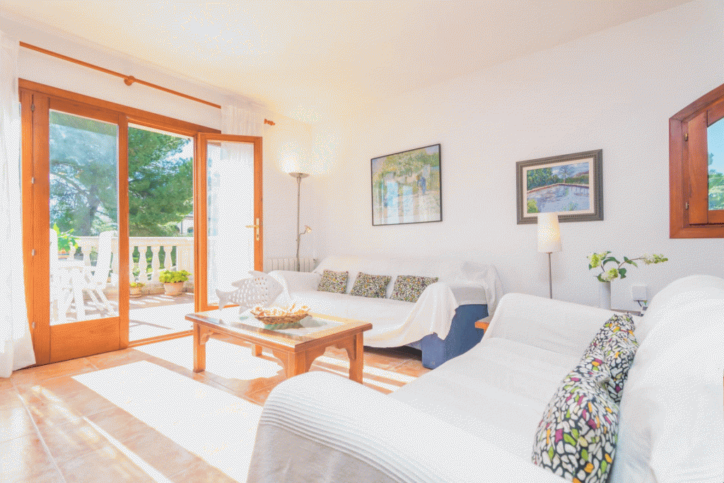 Das gemütliche Wohnzimmer mit Kamin hat direkten Zugang zu einer der vielen Terrassen der Finca „Can Besso“ auf Mallorca