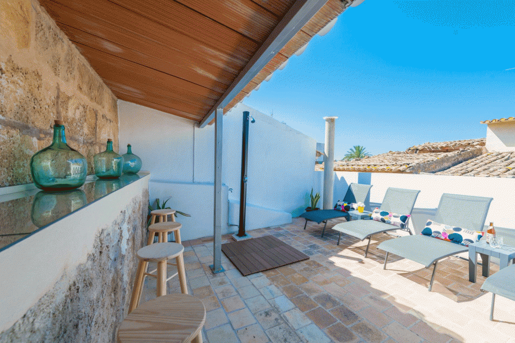 Blick auf die Terrasse mit Sonnenliegen und Bar der Finca „Ca na Serrieta“ in Alcúdia, Mallorca